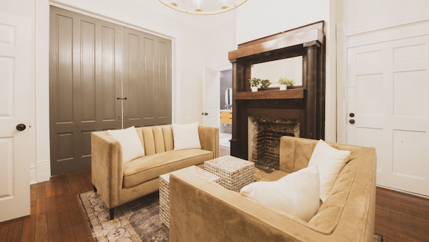 A living room with two beige sofas, a coffee table, and a fireplace.