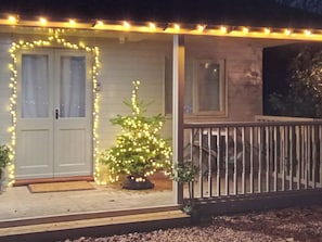 A house with a porch, a Christmas tree, and string lights. - 1 bedroom accommodation in Swaton (Swaton)