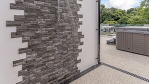 A modern building with a stone wall and a water feature.