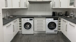 A compact kitchen with white cabinets, a double sink, a Bosch washing machine, and a toaster. - Cannes Villa center pool spa classified (Cannes)