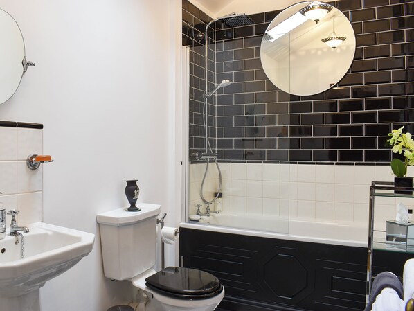 Un baño con inodoro, lavamanos y ducha.