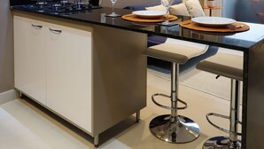 A modern kitchen with a central island, bar stools, and a dining area. - #3 Sophisticated Studio on Boaventura Da Silva (PA)