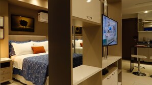 A modern hotel room with a bed, a TV, a desk, and a kitchenette. - #3 Sophisticated Studio on Boaventura Da Silva (PA)