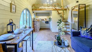 A cozy interior with a dining area, a sofa, a kitchen, and a staircase. - A hidden gem in the stunning Ayrshire countryside. (Straiton, near Maybole)