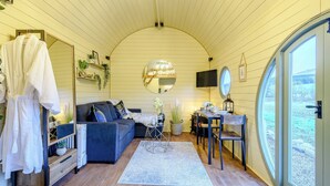 A cozy room with a sofa, a coffee table, a TV, and a large window. - A hidden gem in the stunning Ayrshire countryside. (Straiton, near Maybole)
