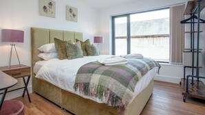 A bedroom with a bed, bedside lamps, a window, and a radiator. - 3 bedroom accommodation in Over Stowey, near Bridgwater (Over Stowey, near Bridgwater)