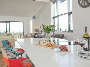 A modern kitchen with a central island, dining area, and large windows. - 3 bedroom accommodation in Over Stowey, near Bridgwater (Over Stowey, near Bridgwater)