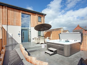 A modern outdoor hot tub area with steps leading to a covered seating area. - 3 bedroom accommodation in Over Stowey, near Bridgwater (Over Stowey, near Bridgwater)
