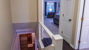 A staircase leading to a bedroom with a bed and a dresser. - PRIME Location with Hot Tub, Pool Table and Sauna (Columbus)