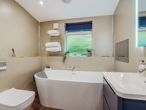 A modern bathroom with a freestanding bathtub, a toilet, and a sink. - Norfolk Broads and Coast, The Beach House (Winterton on Sea)