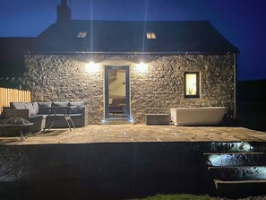 A stone building with a door, a bathtub, and a seating area with a sofa and chairs. - You’ll love this romantic bolthole. (Langley-On-Tyne)