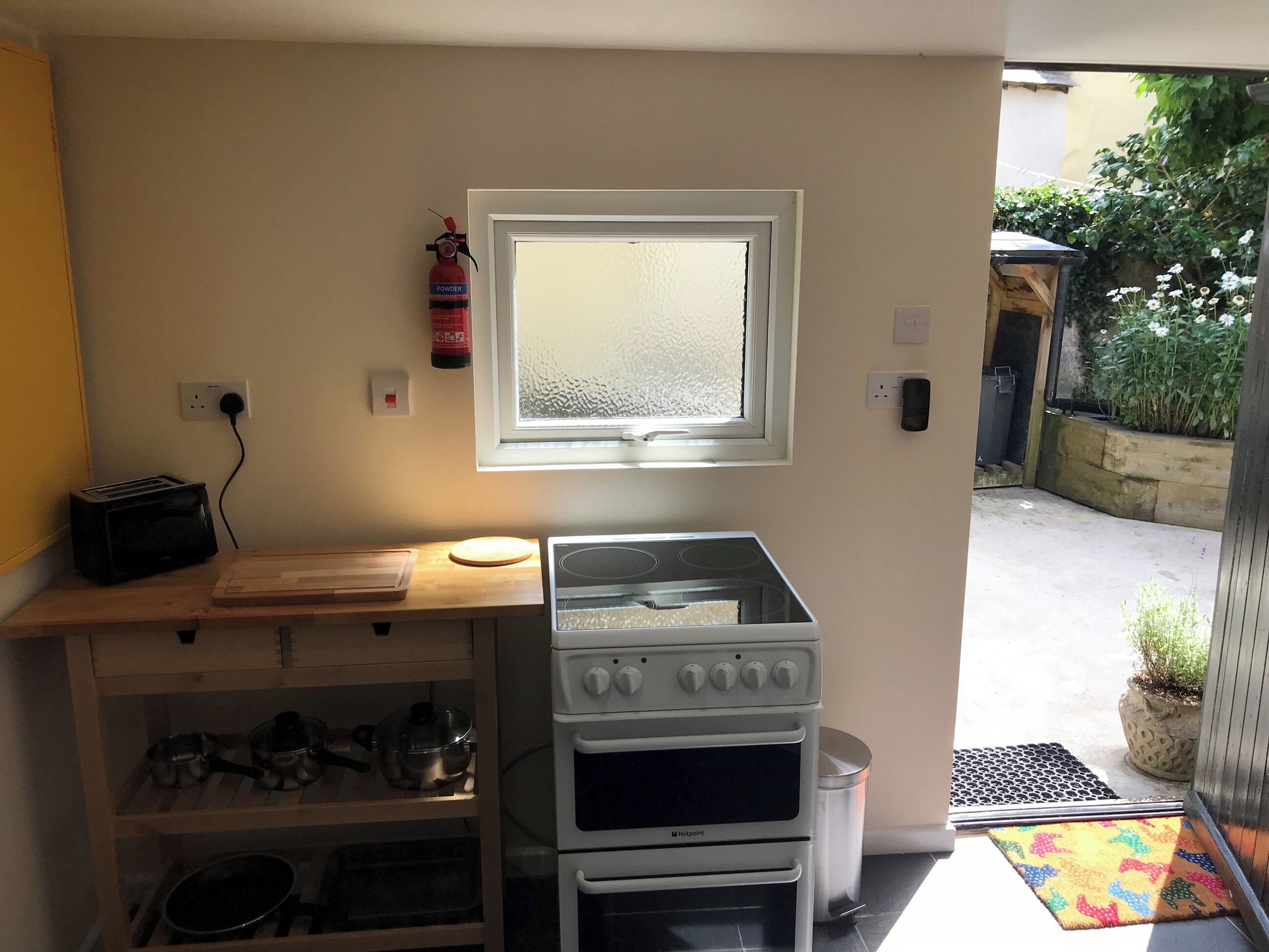 A compact kitchen with a built-in stove, oven, and a window above the sink.