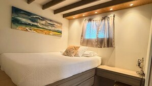 A bedroom with a bed, a desk, and a chair. -  Tiny House in Authentic Japanese Koi Garden in Florida (Homestead)