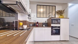 Une cuisine moderne dotée d’un îlot central, d’un four encastré et d’un four à micro-ondes de la marque Bosch.