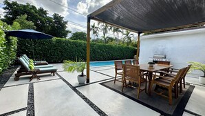 An outdoor patio with a pool, lounge chairs, a table with chairs, and a grill. - Boho Chic House-POOL & FIREPIT - 15 mins to South Beach (El Portal)