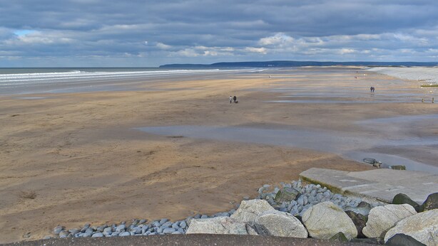 A wide beach with a rocky foreground and a distant view of the sea under a cloudy sky. - The Cottage - UK35177 (Buckland Brewer, near Bideford)