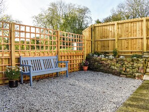 A wooden bench, a lattice fence, and a stone wall with plants. - The Cottage - UK35177 (Buckland Brewer, near Bideford)