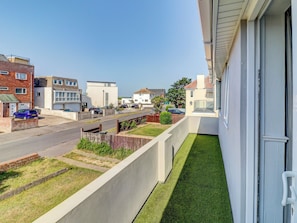 A residential street with houses, a clear sky, and a balcony with a view of the street. - 4 bedroom accommodation in Hayling Island (Hayling Island)