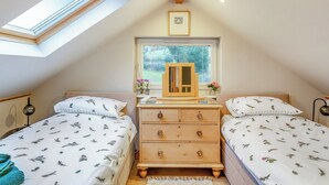 A bedroom with two beds, a wooden dresser, a skylight, and a window with blinds. - 1 bedroom accommodation in Osmotherley (Osmotherley)