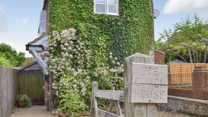 A house with a sign reading "The Coach House" and a wooden gate. - Big skies and open beaches galore. (Great Ryburgh)