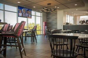 Enjoy a versatile dining experience with a TV, comfortable seating, and a view of the outdoors.