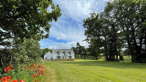 A white building with multiple windows and a lawn in front. - 3 bedroom accommodation in Scaniport (Scaniport)