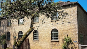 Un bâtiment historique en pierre, doté de fenêtres en arc de cercle et d’une porte traditionnelle.