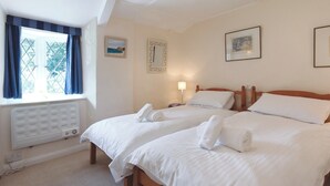 A hotel room with two beds, a window with curtains, a radiator, and framed pictures on the wall. - 1 bedroom accommodation in Batson (Batson)