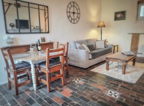 A living room with a dining table, chairs, a sofa, and a coffee table.