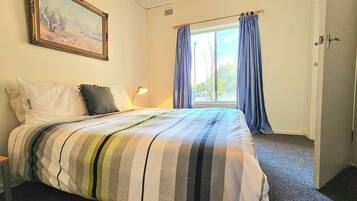 2 dormitorios y tabla de planchar con plancha