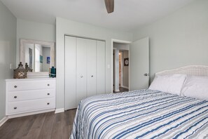 Une chambre à coucher avec un lit, une commode et une armoire.