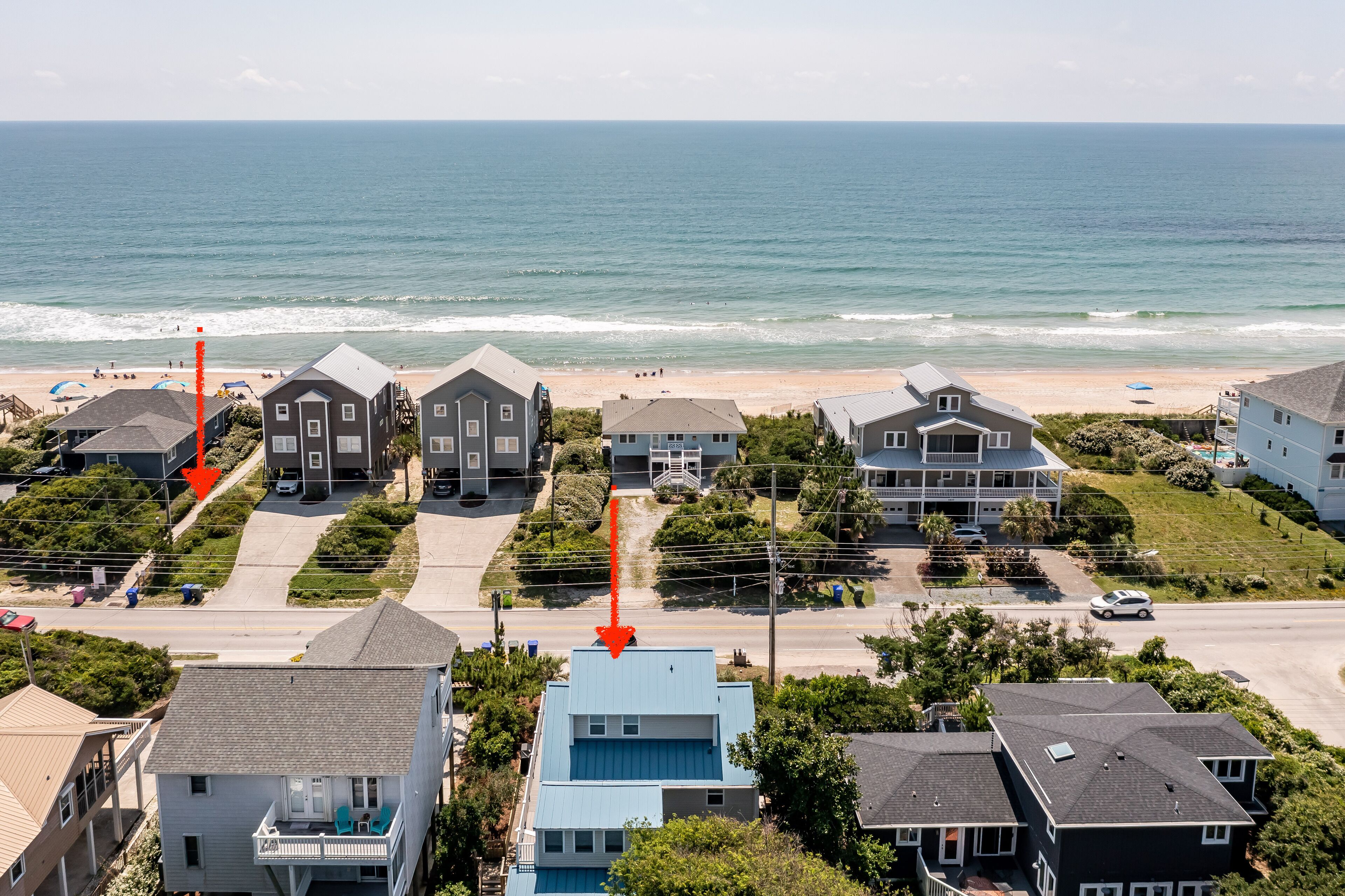 Un quartier résidentiel situé sur la côte, avec des maisons, une plage et une vue dégagée sur l’océan.