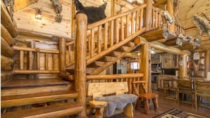 A wooden staircase with a bench and a rug. - Northwoods Log Cabin (Danbury)