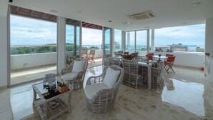 A spacious balcony with wicker furniture, a dining table, and chairs, overlooking a scenic view. - LUXURY HOUSE, CLOSE TO THE BEACH (Manzanillo del Mar)