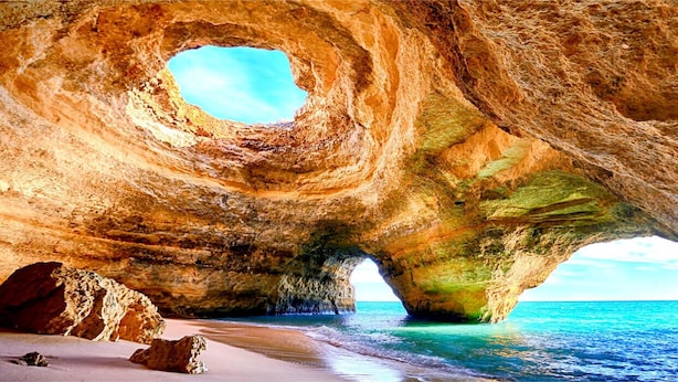 A natural rock formation with a cave-like opening and a beach in the foreground. - A perfect house on the right place with a unique and distinctive location (Faro)