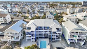 A multi-story hotel with a pool, located in a coastal town. - Beachfront Daze, Oceanfront with Pool (Carolina Beach)
