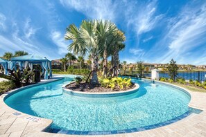 Relax by the serene pool surrounded by lush tropical plants and palm trees.