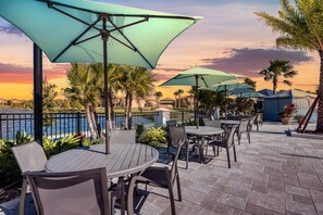 Relax by the poolside patio, where round tables and comfortable chairs are shaded by large umbrellas.
