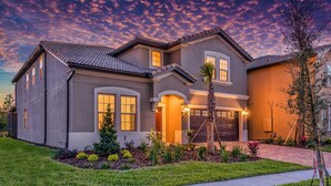Une maison à deux étages avec une pelouse bien entretenue, une allée et un garage.