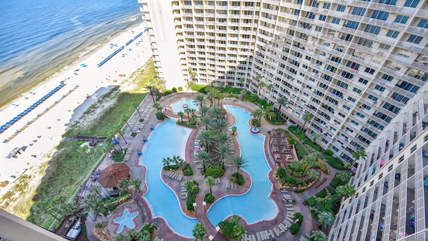 Un hotel moderno con piscina en la azotea, acceso a la playa y exuberante jardinería.