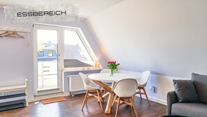 Une pièce moderne comprenant une table à manger, des chaises, un canapé et un radiateur.