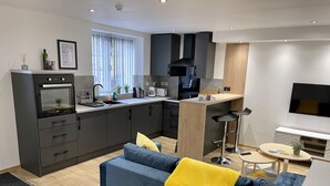 Een modern appartement met keuken, eethoek en woonkamer.