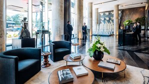 A spacious lobby with modern furniture, a reception desk, and large windows offering views of the outside. - SLS Buenos Aires Puerto Madero (Buenos Aires)
