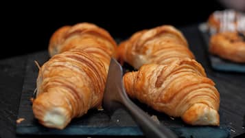 Tres croissants sobre una superficie de pizarra oscura.