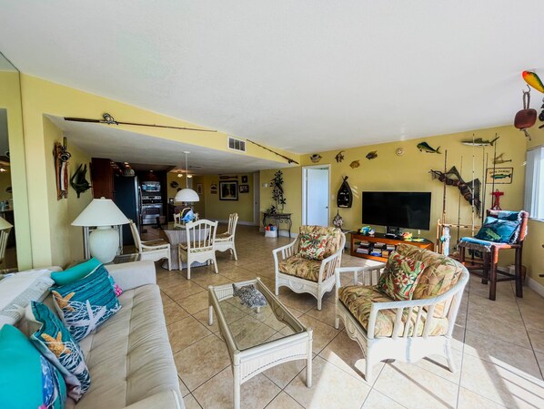 A living room with a sofa, chairs, a coffee table, a TV, and fishing decorations. - Ocean/Marina View - Pool - Free Kayaks Pickleball (Key Largo)