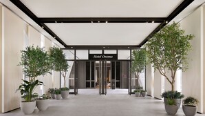 A hotel entrance with a modern design, featuring a glass door entrance, potted plants, and a sign that reads "Hotel Onoma". - Hotel Onoma Daejeon, Autograph Collection (Daejeon)