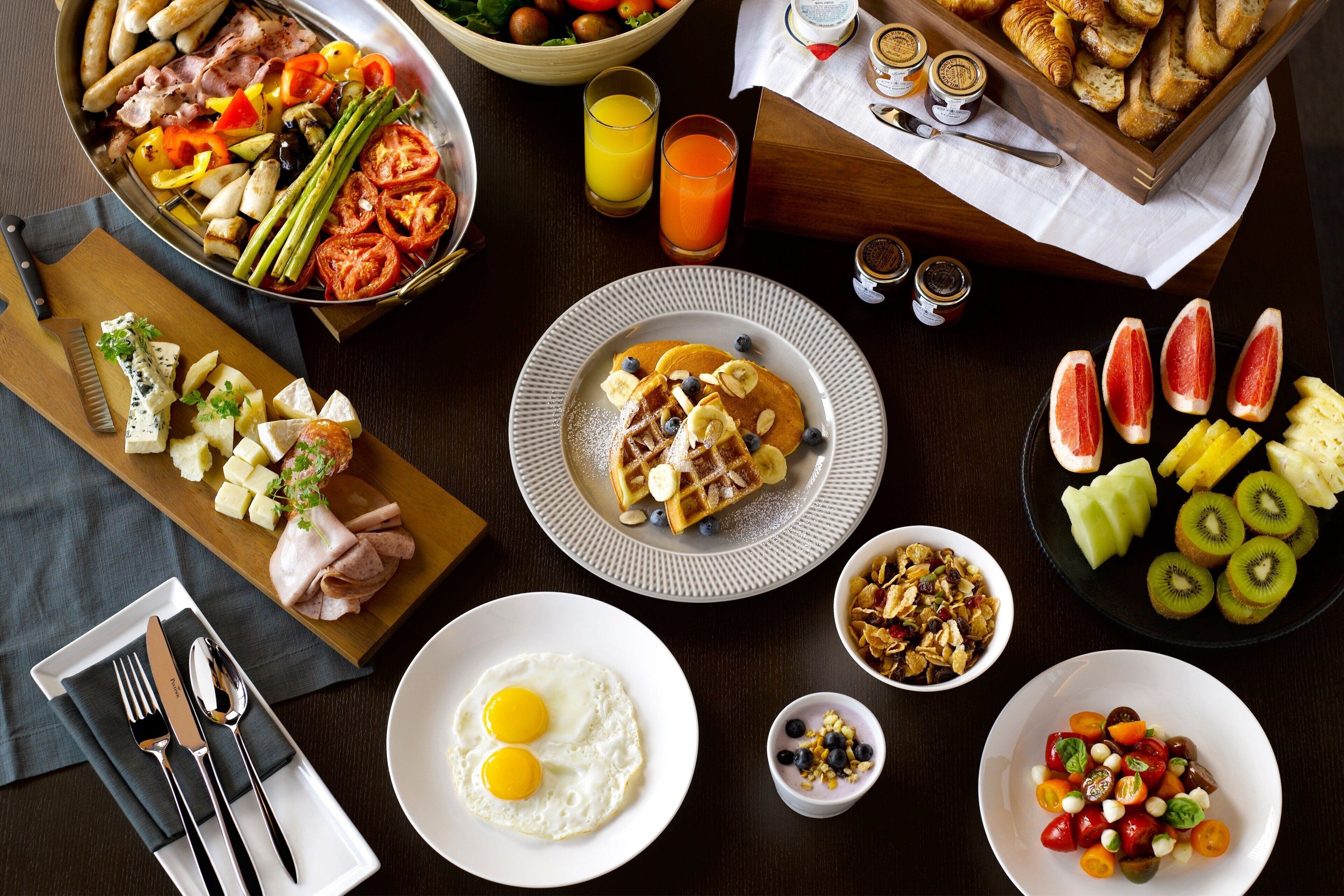 A breakfast spread with various foods and drinks.