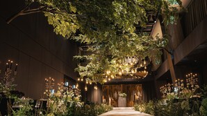 An indoor venue with a central aisle, surrounded by lush greenery and decorative lighting. - Hotel Onoma Daejeon, Autograph Collection (Daejeon)