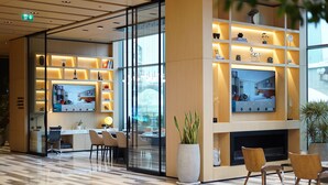 A modern lobby with a reception desk, seating area, and a TV mounted on the wall. - Four Points by Sheraton Istanbul Kagithane (Istanbul)