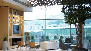 A modern lounge area with a large window, comfortable seating, and a fireplace. - Four Points by Sheraton Istanbul Kagithane (Istanbul)